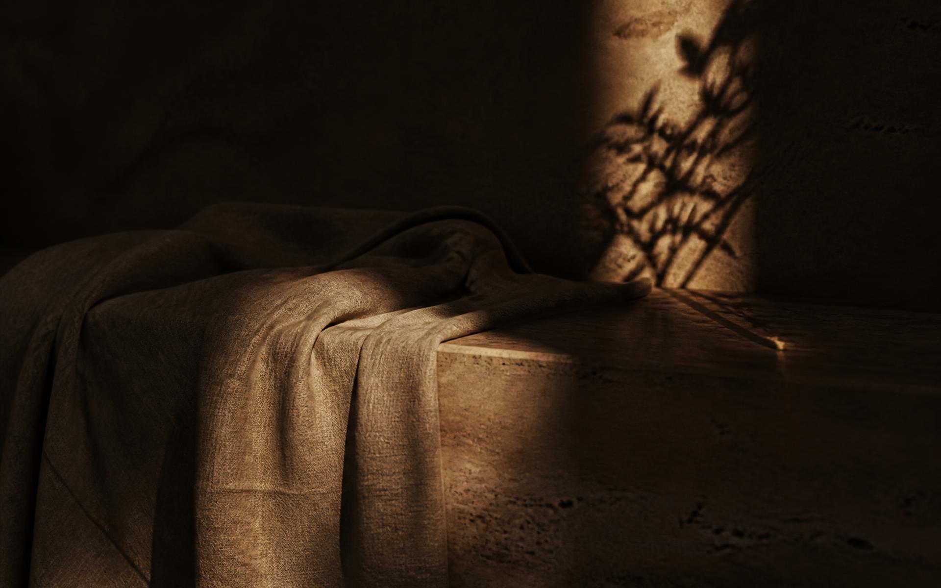 Linen draped over warm travertine stone in low morning light